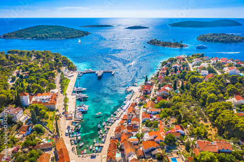 A stunning aerial view of Maslinica on Šolta Island, Croatia, showcasing its picturesque harbor, charming village center, and the scenic archipelago of small islands in front, surrounded by the sea