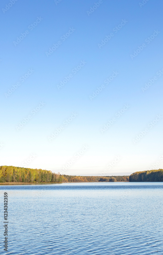 Fototapeta premium Calm lake with a blue sky in the background