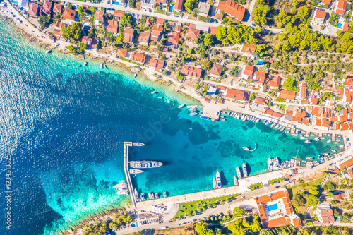 A breathtaking top-down aerial view of Maslinica Bay on Šolta Island, Croatia, capturing the turquoise Adriatic Sea, boats in the marina and the village’s waterfront. photo