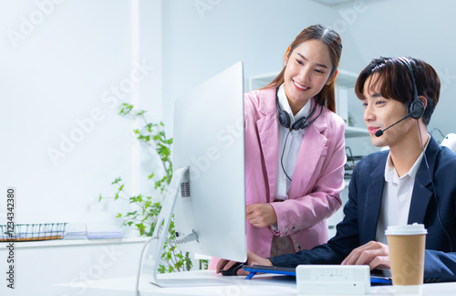 Asian female telemarketing supervisor training, advice and coaching to customer support staff, reading report and online feedback at call center office. Asian woman sale manager training work to team.