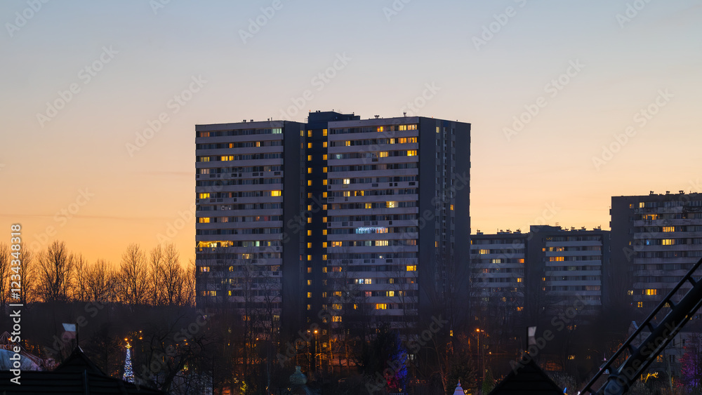 Φωτογραφία Residential buildings with illuminated apartments against the background of a blazing colorful sky