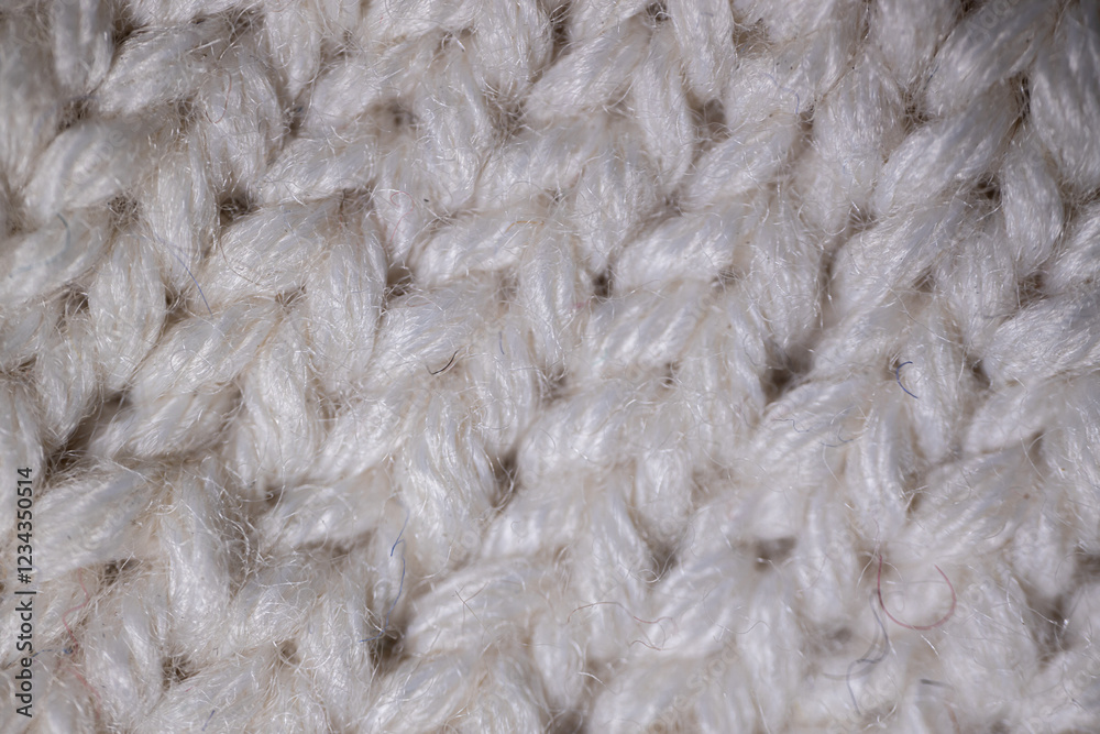 A detailed macro view of white knitted fabric, highlighting the soft, fluffy yarn and intricate weave pattern. The texture emphasizes warmth and comfort. A detailed macro view of white knitted fabric, highlighting the soft, fluffy yarn and intricate weave pattern. The texture emphasizes warmth and comfort.