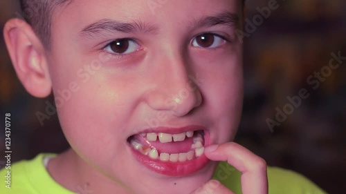 A boy rocks a baby tooth in close-up