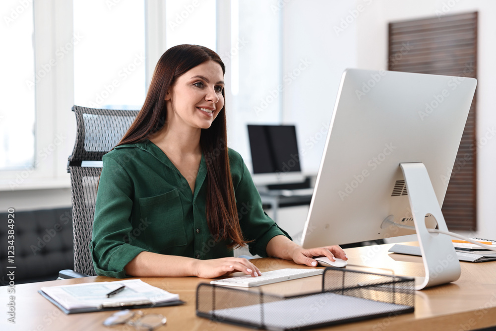 Woman working on computer at table in office Woman working on computer at table in office