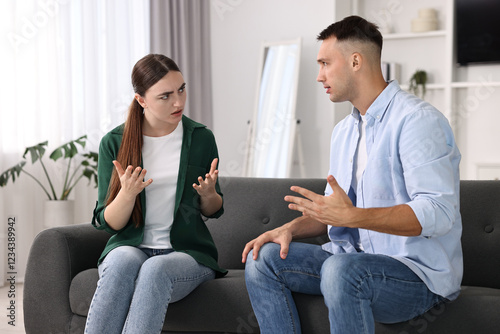 Young couple arguing on sofa at home photo