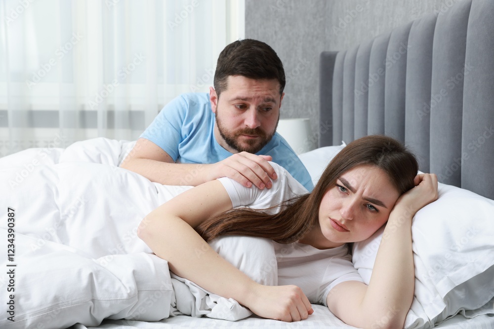 Man comforting his resentful girlfriend on bed at home Man comforting his resentful girlfriend on bed at home