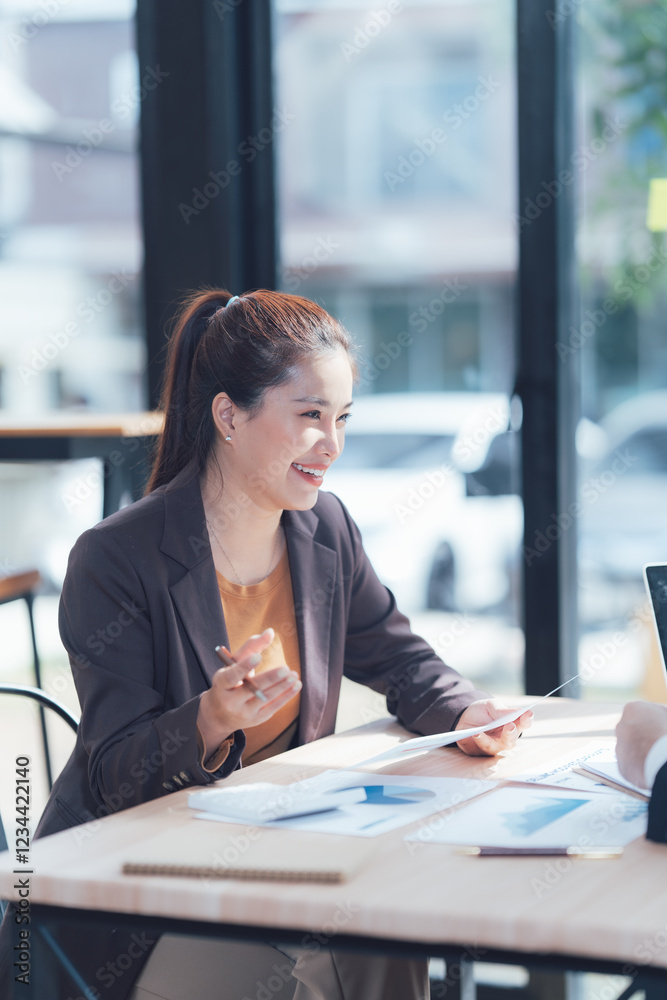 Obraz premium Businesswomen Meeting: A confident businesswoman, radiating warmth and professionalism, engages in a meaningful conversation with a colleague.