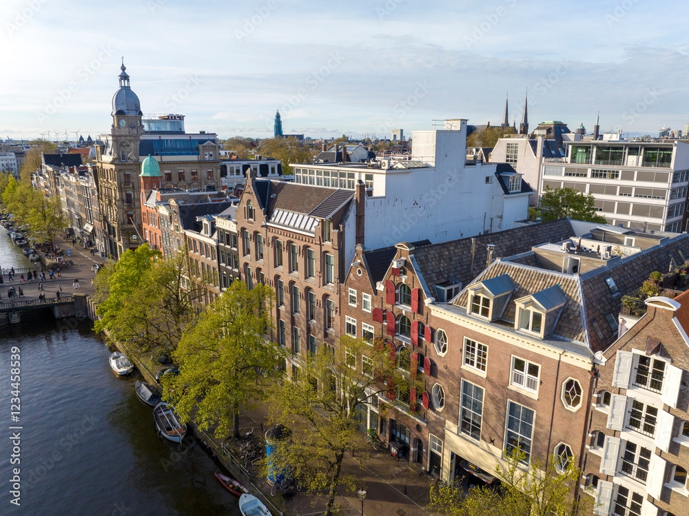 Obraz premium Historical Center of Amsterdam, Netherlands. Aerial Drone Shot of Traditional Dutch houses on narrow street and channel.