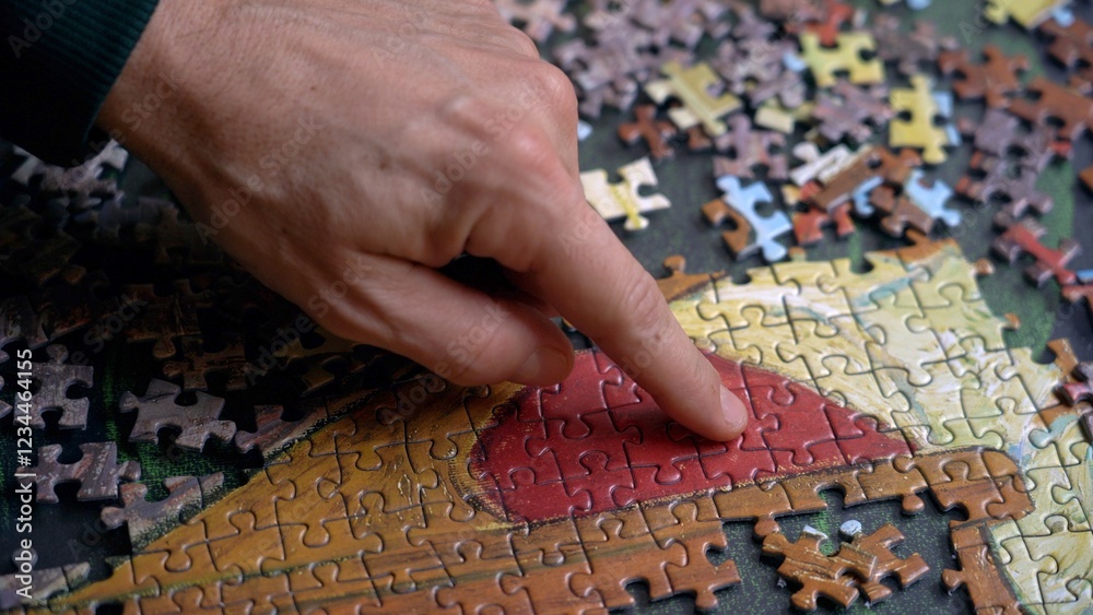 playing at making a puzzle, putting the pieces of the puzzle together to compose a picture in your free time at home with your family - hobby and skills to develop in adolescence