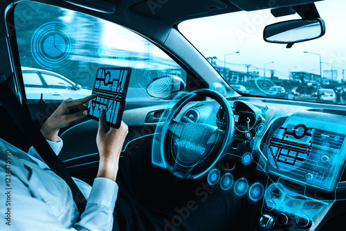 Self-driving autonomous car with relaxed young man sitting at driver seat is driving on busy highway road in the city. Concept of machine learning, artificial intelligence and augmented reality. uds photo