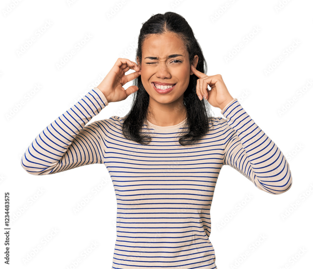Young Filipina woman covering ears with fingers, stressed and desperate by a loudly ambient.