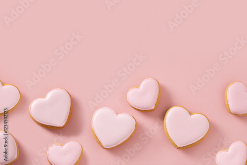 Valentines day greeting card with heart shaped cookies with pink glaze on girly pastel pink background. View from above. Copy space.