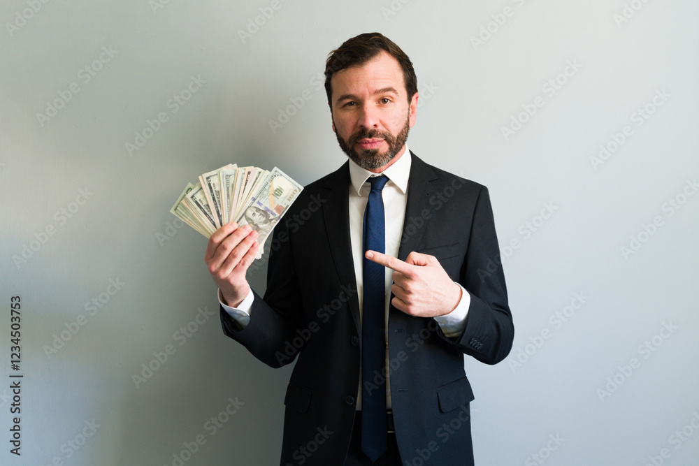 Businessman pointing at money earned with investments Businessman pointing at money earned with investments