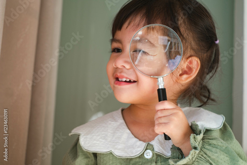 Child exploring with a magnifying glass. photo