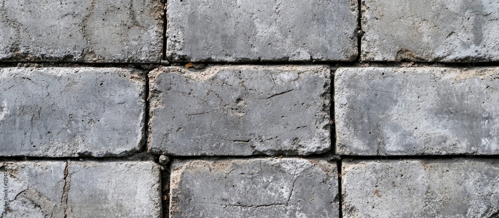Textured pattern of weathered concrete paving stones with irregularities and visible wear, suitable for background use, Copy Space available.