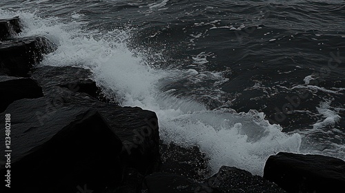 Dark waves crashing on rocks at shoreline photo