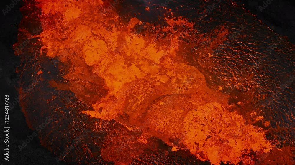 Unique close up view of red hot lava exploding, boiling, and bubbling in the volcano crater, drone shot. Volcanic eruption, natural hazard, and disaster concepts.