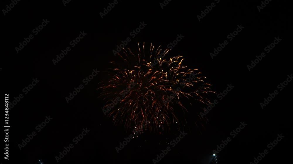 gold red pink sparks scattering fireworks on black night sky.