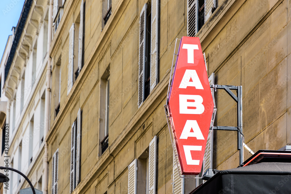 Red french tobacco shop sign with white lettering and a building in the background. Red french tobacco shop sign with white lettering and a building in the background.