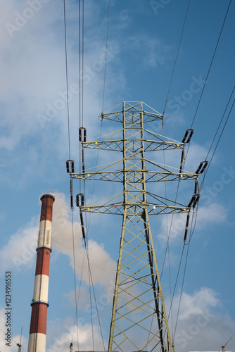 High voltage transmission lines and a chimney emitting harmful greenhouse gases into the atmosphere.
