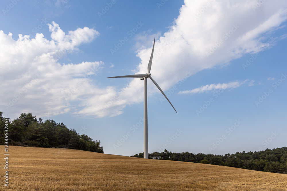 One white wind generator produces alternative energy by wind on the fields in Europe in Spain One white wind generator produces alternative energy by wind on the fields in Europe in Spain
