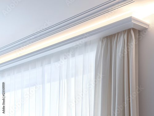 Elegant white cornice framing a window with sheer curtains and soft natural light in a serene space