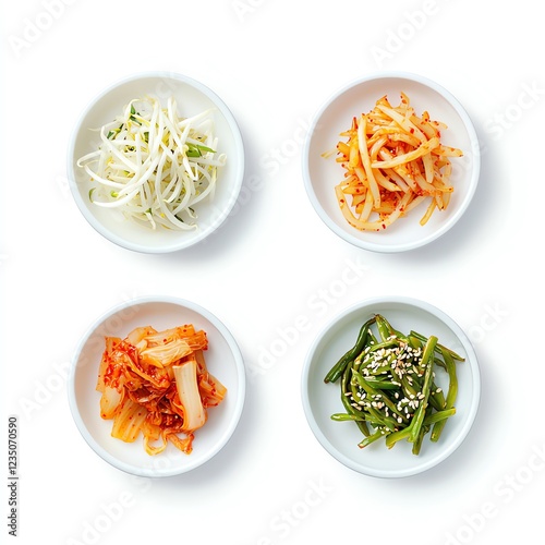 Four varieties of Korean banchan served in white bowls on a white background. Fresh and colorful side dishes include pickled vegetables and seasoned greens. photo