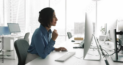 Woman office employee, clerical worker working on PC reviewing reports or financial data, editing emails, proposals, or documents, managing tasks or schedules via project management tools in coworking