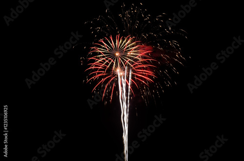 A vibrant firework display lights up the night sky with red and gold