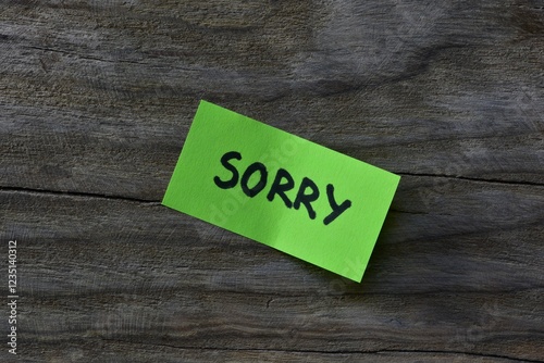 Tableau sur toile Message sorry on green sticky note on wooden board textured background