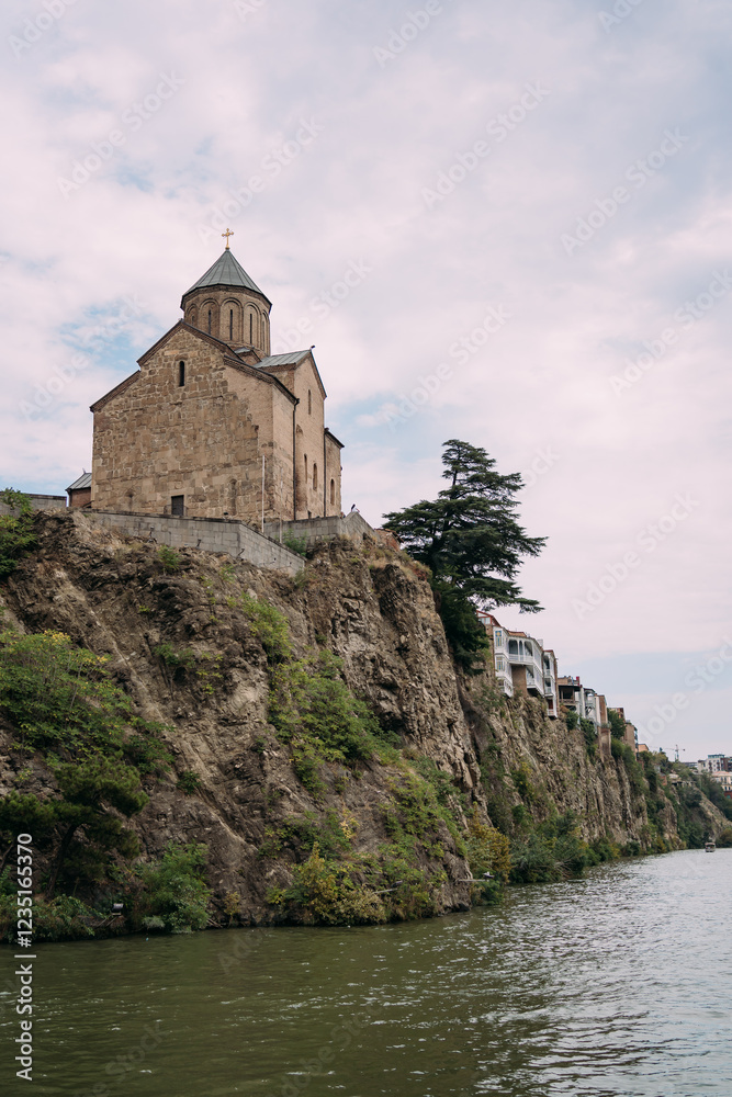 The ancient temple stands on a rocky cliff. Church on the high bank of the river in Tbilisi. Meheti Temple in Tbilisi The ancient temple stands on a rocky cliff. Church on the high bank of the river in Tbilisi. Meheti Temple in Tbilisi