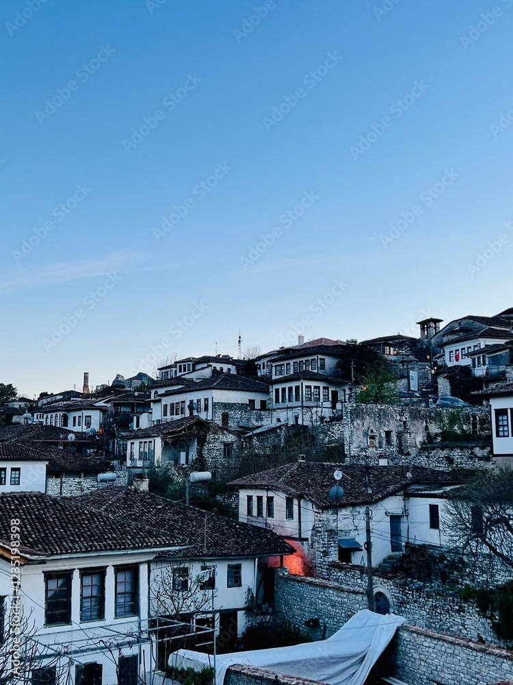 Berat Castle’s ancient building layers, bathed in the soft light after sunset, showcasing the timeless beauty of this historical structure against a tranquil evening backdrop. Berat Castle’s ancient building layers, bathed in the soft light after sunset, showcasing the timeless beauty of this historical structure against a tranquil evening backdrop.