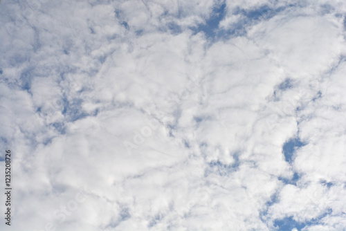 A bright blue sky filled with fluffy white altocumulus clouds photo