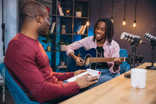 Slika na platnu African American musician performing acoustic guitar while engaging with intervi