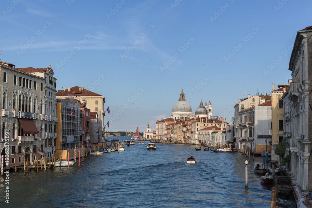Grand Canal top attraction in Venice, Italy with beautiful architectural buildings, busy water traffic, and a majestic church Santa Maria della Salute.
