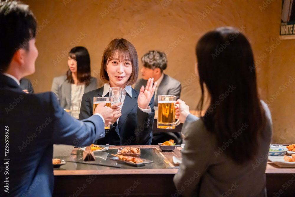 居酒屋で新入社員の歓迎会をするビジネスパーソン