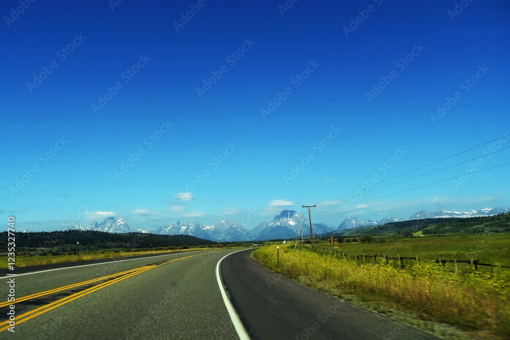 Distant mountain peaks of Grand Teton National Park, view from the car. Distant mountain peaks of Grand Teton National Park, view from the car.