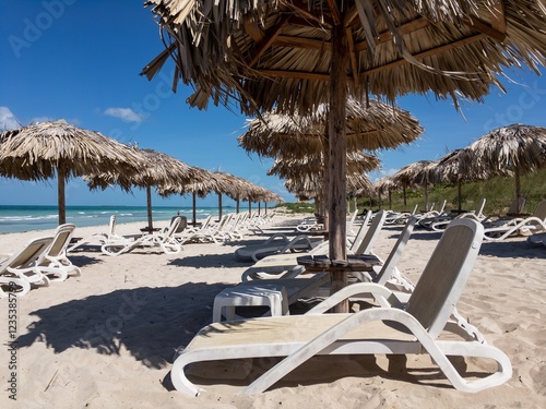 Empty sand beach in Varadero, Cuba. White sunbeds, straw umbrellas and ocean