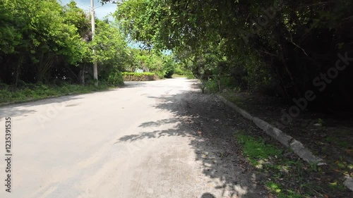 Walking in on the side of a road in Mexico as a data construction truck passes on a paved and gravel road in port town of costa maya, Mahahual, Mexico
