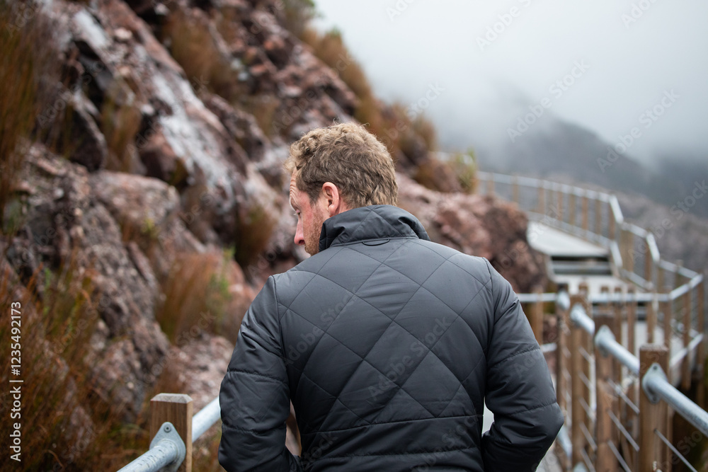 Fototapeta premium man behind walking path hike mountains cold winter jacket