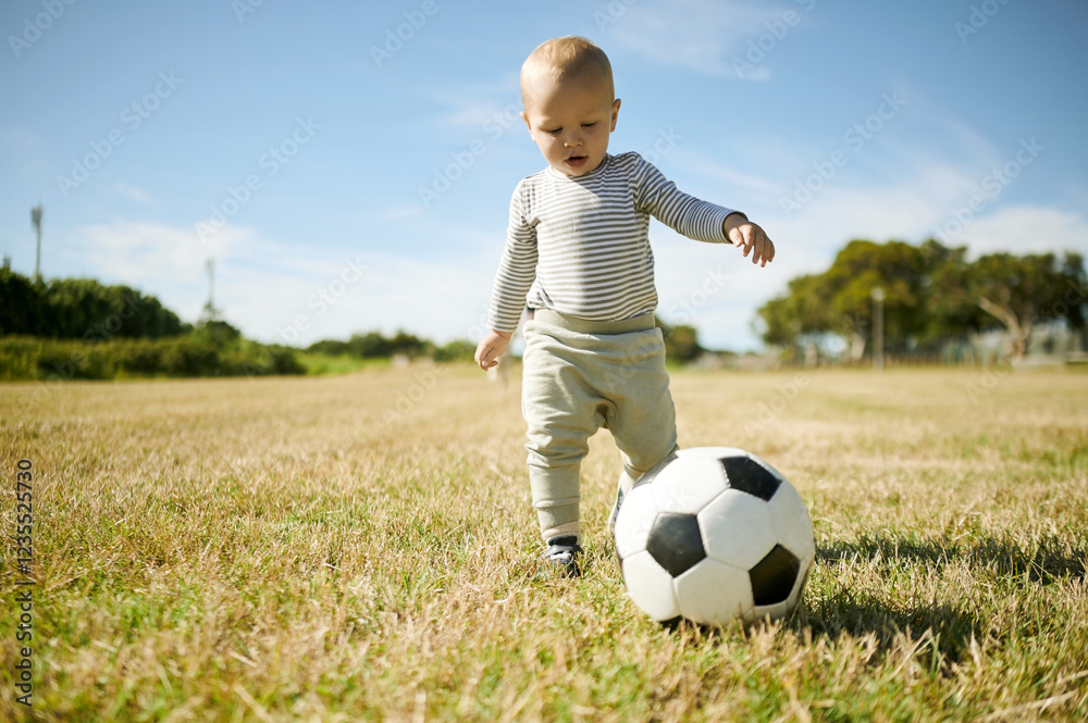 Outdoor, baby and soccer ball on a grass field with mobility development and growth in nature. Child, park and kicking toddler with sport equipment with a kids toy in the summer sun ready to learn Outdoor, baby and soccer ball on a grass field with mobility development and growth in nature. Child, park and kicking toddler with sport equipment with a kids toy in the summer sun ready to learn