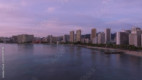 Wallpaper Mural Serene aerial view of Waikiki Beach purple sunset in Honolulu with a slow pan, showing the skyline, Royal Hawaiian Hotel, calm ocean, and distant mountains. Torontodigital.ca