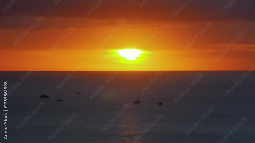 Sunset over calm ocean waters in Oahu, Hawaii, with vibrant hues reflecting on the sea. Two sailboats float gently under a clear horizon. Sunset over calm ocean waters in Oahu, Hawaii, with vibrant hues reflecting on the sea. Two sailboats float gently under a clear horizon.