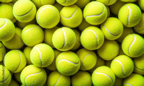 A dense collection of bright yellow tennis balls filling the entire frame view