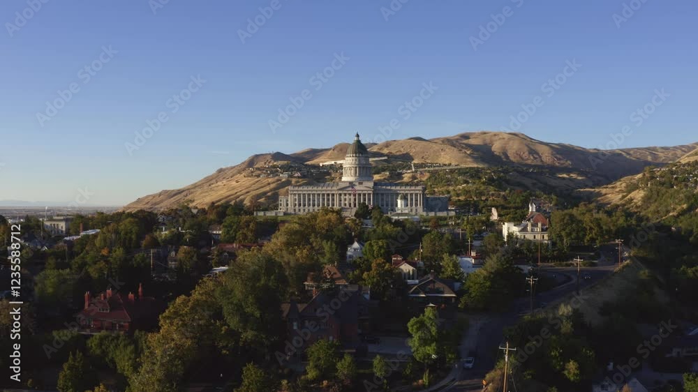 Aerial drone shot of the Utah Capitol in Salt Lake City. The camera dollies in towards Capitol Hill, homes, and vibrant fall trees glowing during a sunny autumn day. Aerial drone shot of the Utah Capitol in Salt Lake City. The camera dollies in towards Capitol Hill, homes, and vibrant fall trees glowing during a sunny autumn day.