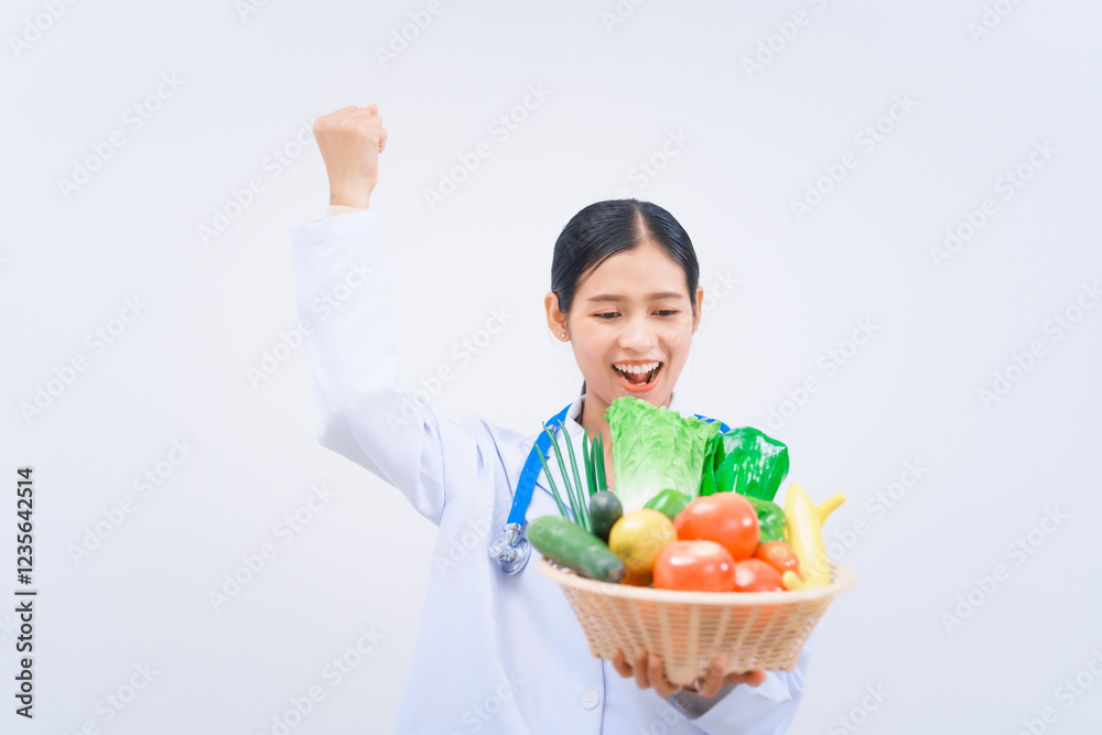 A young Asian woman nutritionist in a white lab coat, holding fruit and vegetable basket, smiling happily against white background. dietary nutrients, metabolism, and promoting health. A young Asian woman nutritionist in a white lab coat, holding fruit and vegetable basket, smiling happily against white background. dietary nutrients, metabolism, and promoting health.