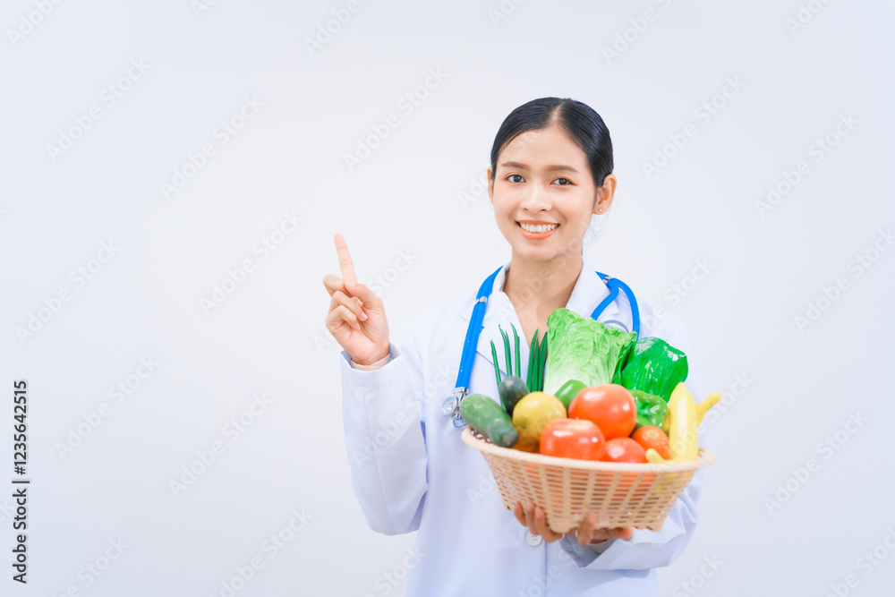 A young Asian woman nutritionist in a white lab coat, holding fruit and vegetable basket, smiling happily against white background. dietary nutrients, metabolism, and promoting health. A young Asian woman nutritionist in a white lab coat, holding fruit and vegetable basket, smiling happily against white background. dietary nutrients, metabolism, and promoting health.