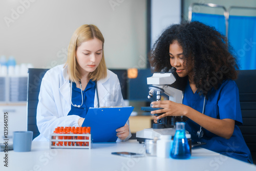 Young African American and Russian woman, both scientists, collaborate to analyze blood samples, viruses, vaccines using microscopes. They conduct crucial medical and biological research. photo