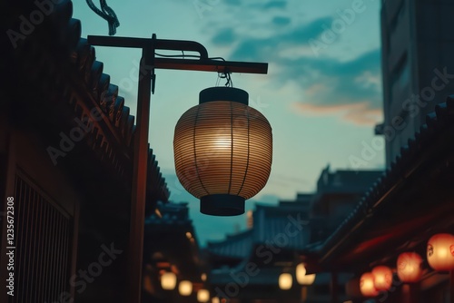 The towering lantern at SensÅ-ji Temple in Tokyo illuminated during twilight, surrounded by traditional architecture. photo