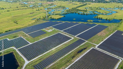 Tableau sur toile Drone shot aerial view solar energy array provides renewable power in large scale facility surrounded by greenery and water in rural place